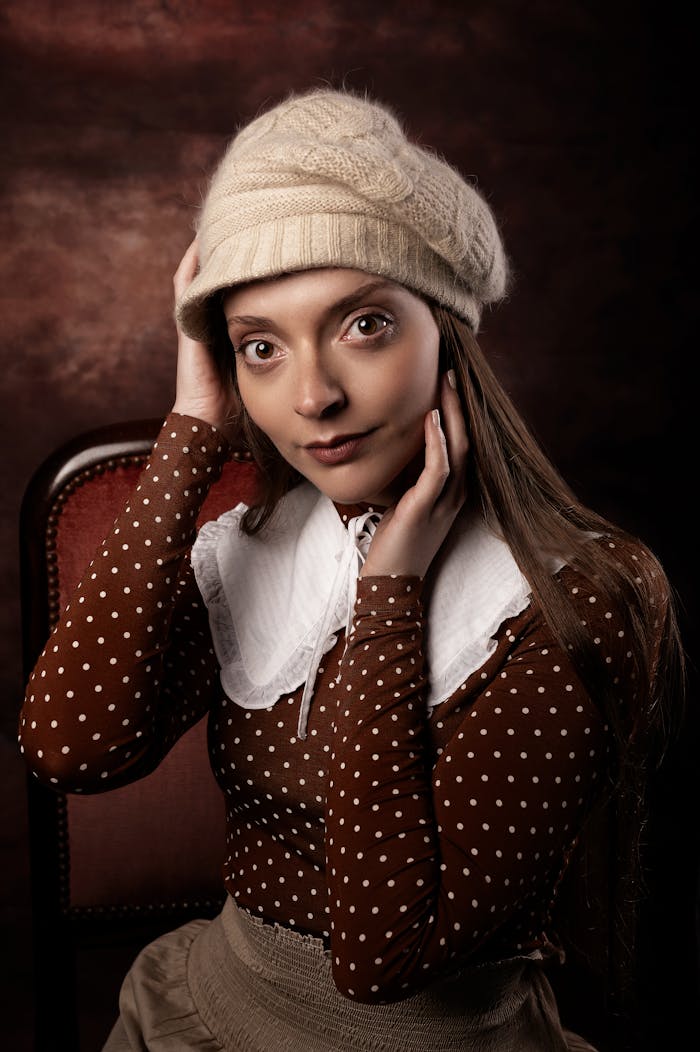 Charming woman in polka dot outfit and knit hat, captured in a vintage style portrait.